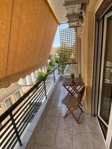 a balcony with a table and a chair on a building at Modern Rous Apartment in Athens in Athens