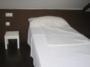 a white bed with a white comforter and white pillows at Residencia Universitaria San José in Málaga
