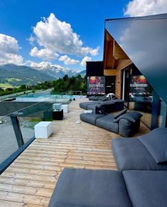 eine Terrasse mit mehreren Sofas und einem Pool in der Unterkunft Das Liftplatzl in Sankt Michael im Lungau