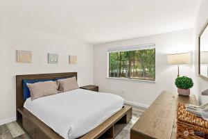Schlafzimmer mit einem Bett, einem Tisch und einem Fenster in der Unterkunft Secluded Sanctuary With a View of The Puget Sound in Gig Harbor