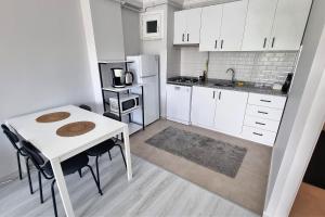 cocina con mesa blanca y nevera blanca en 2 BR Tower View Retreat, en Estambul