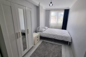 um pequeno quarto com uma cama e um espelho em 2 BR Tower View Retreat em Istambul