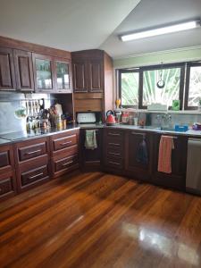 a kitchen with wooden cabinets and a wooden floor at Homestay at Julie's in Cairns