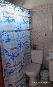 baño con cortina de ducha con mariposas azules en Descanso al Paso Chuy, en Chuy