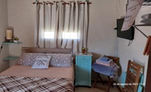 楚伊的住宿－Descanso al Paso Chuy，一间卧室配有一张床、一张桌子和一个窗户。