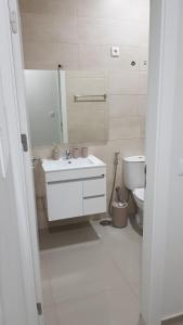 a white bathroom with a sink and a toilet at Apartamentos Beira-Mar in Mindelo
