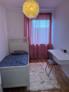 1 dormitorio con cama, escritorio y ventana en Rum i lyxig lägenhet nära Emporia, en Malmö