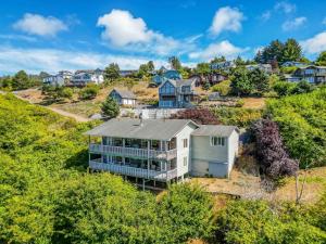 eine Luftansicht eines Hauses auf einem Hügel mit Häusern in der Unterkunft Neskowin Eyrie - Meredith Lodging in Neskowin