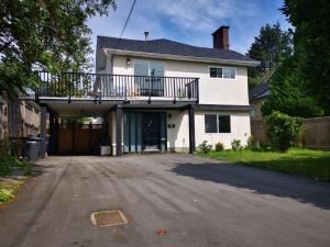 Casa blanca con balcón en la entrada en Yan lovely little house en Burnaby