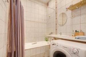 y baño con lavadora y bañera. en Private rooms with balcony next to station, en Vilna