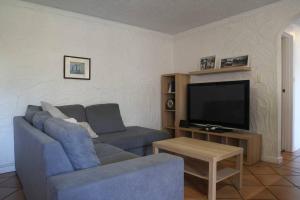 a living room with a blue couch and a tv at Sunsets At Glenelg in Glenelg