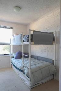 a bedroom with two bunk beds and a window at Sunsets At Glenelg in Glenelg