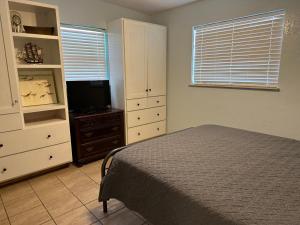 um quarto com uma cama, uma cómoda e uma televisão em Surfside Shangri La em Daytona Beach