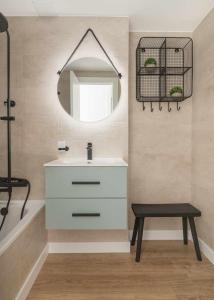 een badkamer met een witte wastafel en een spiegel bij Elurra II Confort in Formigal
