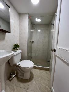 een badkamer met een douche, een toilet en een wastafel bij Maja Hospedaje Apartamento con aire frente al Mar in Cartagena