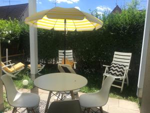 - une table et des chaises sous un parasol sur la terrasse dans l'établissement Ferienwohnung am Bodensee, à Öhningen