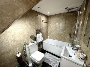 2 Bed Sleeps 6 - Walking distance to Leeds City Centre!! في ليدز: حمام مع مرحاض وحوض استحمام ومغسلة