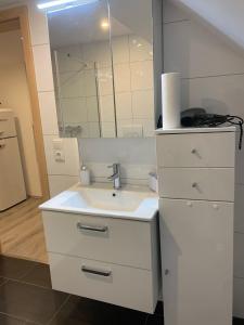 a white bathroom with a sink and a mirror at Haus CM in Nüziders