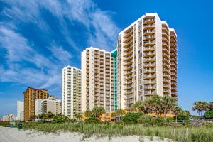 a tall white building on the beach with buildings at Oceanview Studio Escape With Beach Steps Away! 1828 in Myrtle Beach