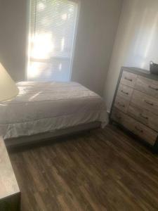 a bedroom with a bed and a dresser and a window at Cozy 4 Bedroom Near Airport in Montgomery