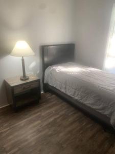 a bedroom with a bed and a lamp on a night stand at Cozy 4 Bedroom Near Airport in Montgomery