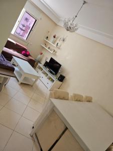 una sala de estar blanca con mesa y sillas en appartement in al hoceima, en Alhucemas