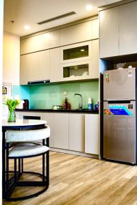 cocina con mesa y nevera en Sam's homestay-Solforest 2 bedrooms apartment, en HÆ°ng YÃªn