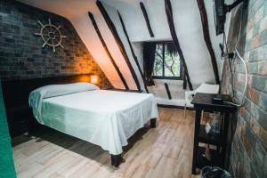 1 dormitorio con cama y pared de ladrillo en Hotel Villas Tiburon, en Isla Holbox