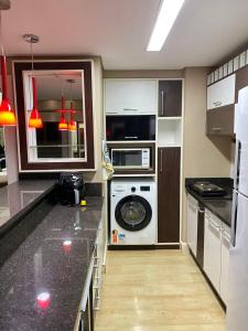 a kitchen with a washer and dryer in it at Saint Sebastian Flat 612 - Com Hidro! até 4 pessoas, Duplex, no centro in Jaraguá do Sul