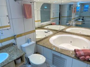 a bathroom with two sinks and a tub and a toilet at Saint Sebastian Flat 612 - Com Hidro! até 4 pessoas, Duplex, no centro in Jaraguá do Sul