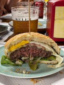 a sandwich on a plate with a glass of beer at Hotel Rural Quintanapalla in Quintanapalla
