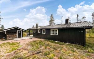 a black house with a garage in a field at Pet Friendly Home In stby With Wifi in Østby