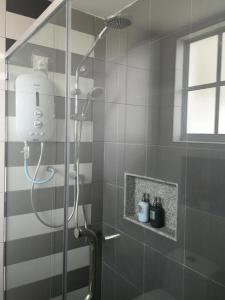 a shower with a glass door in a bathroom at The Trails of Kampar in Kampar