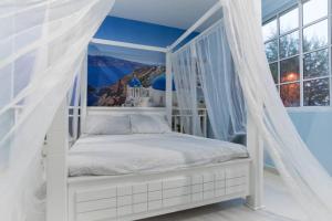 un letto a baldacchino bianco in una stanza con finestra di The Trails of Kampar a Kampar