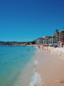 a beach with a bunch of people in the water at New apartment at 150m from the beaches Easy check in in Juan-les-Pins