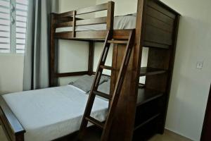 a bunk bed with a ladder next to a bed at Casa Carmen Culebra- Suez in Culebra