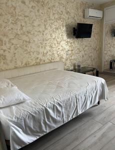 a bedroom with a white bed with a tv on the wall at Benal Beach in Benalmádena