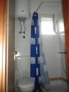 a bathroom with a toilet and a blue shower curtain at Apartmentsin Pasman with Air condition, WIFI 4650-1 -2 in Pašman +36 photos