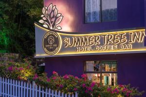 un edificio púrpura con un cartel para una cafetería del hotel en Summer Tree Inn (The Captain's Hostel) en Sanya