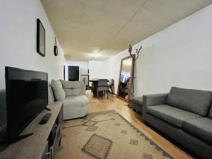 sala de estar con sofá y TV en Cómoda casa con dos cuartos y cochera para auto pequeño, en Guadalajara