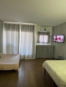 a bedroom with two beds and a flat screen tv at Benal Beach Apartment in Benalmádena