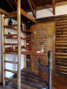 a tasting room in a wooden cabin with a wooden shelf at Cabaña los Aromos in Maipú