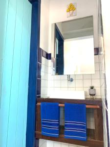 duas toalhas azuis num balcão na casa de banho em Maria Flor Pousada em Taíba