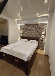 a large bed in a room with a brick wall at Santorini colombiano en Doradal in Puerto Triunfo