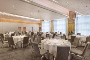 a banquet room with tables and chairs with white tablecloths at Sheraton Grand Hotel & Spa in Edinburgh