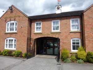 a red brick building with a door with a clock on it at The Atherstone Red Lion Hotel in Atherstone
