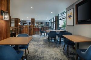 a restaurant with tables and chairs and a flat screen tv at Delta Hotels by Marriott Edinburgh in Edinburgh