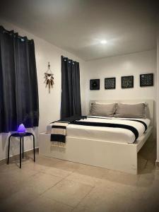 a bedroom with a large white bed with black curtains at Rota- Casa Carmen Culebra in Culebra