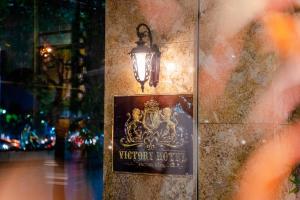 um sinal na parede com uma luz sobre ele em Victory Hotel em Hanói