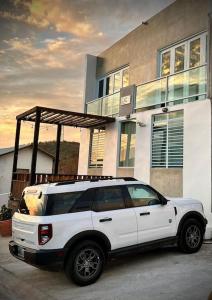 una camioneta blanca estacionada frente a una casa en Rota- Casa Carmen Culebra, en Culebra